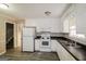 Bright kitchen with white appliances and cabinets, modern vinyl floors, and ample natural light from the window above the sink at 115 Fairview Way, Stockbridge, GA 30281