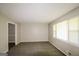Bright living room with neutral walls, new carpet, and a large window providing natural light, creating a cozy atmosphere at 115 Fairview Way, Stockbridge, GA 30281