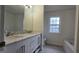 Bright bathroom featuring a double sink vanity, framed mirror, and large tub at 1525 Racquet Club Dr, Lawrenceville, GA 30043