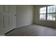 Bright, empty bedroom with wood-look floors and natural light from a large window at 1525 Racquet Club Dr, Lawrenceville, GA 30043