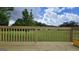 A wooden deck offers a vantage point to enjoy the beautiful, tree-lined, grassy backyard at 1525 Racquet Club Dr, Lawrenceville, GA 30043