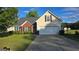 Charming home featuring well-kept lawn, a two-car garage, and classic siding at 1525 Racquet Club Dr, Lawrenceville, GA 30043