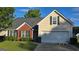 Traditional home boasting a manicured lawn, and an attached two-car garage at 1525 Racquet Club Dr, Lawrenceville, GA 30043