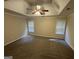 Spacious carpeted bedroom with a tray ceiling and natural light from two windows at 4551 Mitchells Meadow Ln, Ellenwood, GA 30294