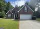 Charming brick home with a two-car garage and well-manicured lawn at 4551 Mitchells Meadow Ln, Ellenwood, GA 30294