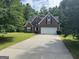 Red brick home with a two-car garage and mature trees at 4551 Mitchells Meadow Ln, Ellenwood, GA 30294