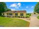 Charming yellow house with black shutters, manicured front lawn, and detached two-car garage at 183 Brookwood Estates Trl, Stockbridge, GA 30281