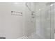 Bright bathroom featuring a glass shower enclosure with modern fixtures and white marble-style tiling at 2622 Murdock, Marietta, GA 30062