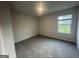 Bright bedroom with plush carpet, neutral paint, and natural light from the window at 11045 Shadow Creek Ter # 65, Hampton, GA 30228
