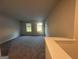 Spacious bonus room with neutral paint, plush carpet, and bright natural light streaming through windows at 11045 Shadow Creek Ter # 65, Hampton, GA 30228