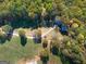 Overhead view of wooded acreage, a home, shed, and pastures on a secluded lot at 335 Gum Creek Rd, Roopville, GA 30170