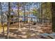 The spacious backyard shows the house and outbuildings nestled amongst the trees at 335 Gum Creek Rd, Roopville, GA 30170