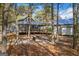 Backyard featuring mature trees, a fire pit, a house with a screened-in porch, and a small outbuilding at 335 Gum Creek Rd, Roopville, GA 30170