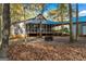 Backyard featuring mature trees, a fire pit, a house with a screened-in porch, and a small outbuilding at 335 Gum Creek Rd, Roopville, GA 30170