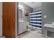 Well-lit bathroom featuring a vanity, toilet, striped shower curtain and neutral decor at 335 Gum Creek Rd, Roopville, GA 30170