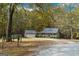 Charming home with a front porch and a detached garage surrounded by lush trees at 335 Gum Creek Rd, Roopville, GA 30170