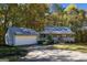 Charming home with a welcoming front porch and a detached garage surrounded by lush trees at 335 Gum Creek Rd, Roopville, GA 30170