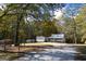 Exterior view of a home featuring a front porch, detached garage, and a wooded area at 335 Gum Creek Rd, Roopville, GA 30170