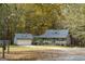 Exterior view of a charming home with a detached garage surrounded by trees at 335 Gum Creek Rd, Roopville, GA 30170