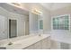 Spacious bathroom with double vanity, large mirror, soaking tub, and window at 5523 Forest Dr, Loganville, GA 30052