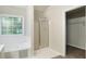 Bright bathroom featuring a soaking tub, shower, and large window at 5523 Forest Dr, Loganville, GA 30052