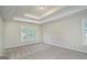 Large bedroom with tray ceiling, neutral carpet, and plenty of natural light at 5523 Forest Dr, Loganville, GA 30052