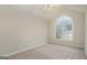 Bright bedroom with neutral walls, carpet floors, ceiling fan and a large arched window at 5523 Forest Dr, Loganville, GA 30052