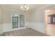 Cozy dining room with wainscoting, neutral carpet, and a view of the backyard at 5523 Forest Dr, Loganville, GA 30052