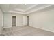 Spacious main bedroom with a tray ceiling, neutral carpet, and ensuite bathroom access at 5523 Forest Dr, Loganville, GA 30052