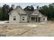 Charming single-Gathering home featuring a mix of stone and board and batten siding with a covered entryway and a gray shingle roof at 49 Durham Estates Dr, Sharpsburg, GA 30277