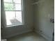 The laundry room features a window with outdoor view, adding natural light and has white shelving for storage at 49 Durham Estates Dr, Sharpsburg, GA 30277