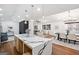 Open kitchen with modern island, stainless appliances, and hardwood floors leading to living area at 2541 Peyton Woods Sw Trl, Atlanta, GA 30311