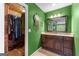 Bathroom featuring a spacious walk-in closet, vanity with ample cabinet space, and green accent wall at 101 Jasmine Path, Peachtree City, GA 30269