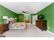 Large primary bedroom with green walls, carpet, ceiling fan, and ensuite bathroom at 101 Jasmine Path, Peachtree City, GA 30269