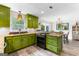Charming kitchen featuring green cabinets, granite countertops, and stainless steel range and wood laminate flooring at 101 Jasmine Path, Peachtree City, GA 30269