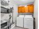 Efficient laundry room with washer, dryer, shelving, and cabinetry for organized storage at 101 Jasmine Path, Peachtree City, GA 30269
