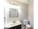 Powder room with vanity sink, ornate mirror, toilet, and hardwood floors at 1416 Emerald Pine Ct, Lawrenceville, GA 30043