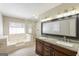 Bathroom features large soaking tub, glass shower, double sink vanity, and large mirror at 1416 Emerald Pine Ct, Lawrenceville, GA 30043