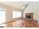 Open living room with hardwood flooring, fireplace, and ample natural light from large windows at 1416 Emerald Pine Ct, Lawrenceville, GA 30043