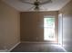 Spacious bedroom with neutral walls, carpet, ceiling fan, and a view of the exterior at 5799 Eagles Feather Ln, Riverdale, GA 30274
