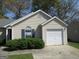 Charming single-story home featuring light siding, manicured landscaping, and an attached one-car garage at 5799 Eagles Feather Ln, Riverdale, GA 30274