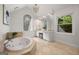 Bright bathroom featuring a jacuzzi-style tub, elegant fixtures, and stained glass window accents at 1260 Heards Ferry Rd, Sandy Springs, GA 30328