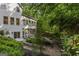 Rear view of a well-maintained home with surrounding garden and greenery in a tranquil setting at 1260 Heards Ferry Rd, Sandy Springs, GA 30328