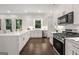 Open kitchen with sleek white cabinets, quartz counters, and stainless appliances offers a modern design at 1260 Heards Ferry Rd, Sandy Springs, GA 30328
