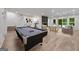 Spacious living room featuring a pool table, chairs, and sliding doors to the pool at 1260 Heards Ferry Rd, Sandy Springs, GA 30328