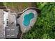 An aerial view shows a kidney-shaped pool nestled among mature trees and next to a deck at 1260 Heards Ferry Rd, Sandy Springs, GA 30328