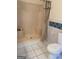 Functional bathroom showcasing a stand-up shower and toilet, complemented by white tile flooring at 191 Lagrange St, Grantville, GA 30220