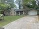 Charming one-story home with a front yard, mature trees, and a paved driveway leading to an attached garage at 191 Lagrange Street, Grantville, GA 30220