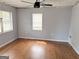 Bedroom with hardwood floors, two windows, light gray walls, and a ceiling fan at 305 Anderson Cir, Covington, GA 30016