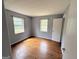 Bedroom with hardwood floors and light blue walls with white trim and two windows at 305 Anderson Cir, Covington, GA 30016